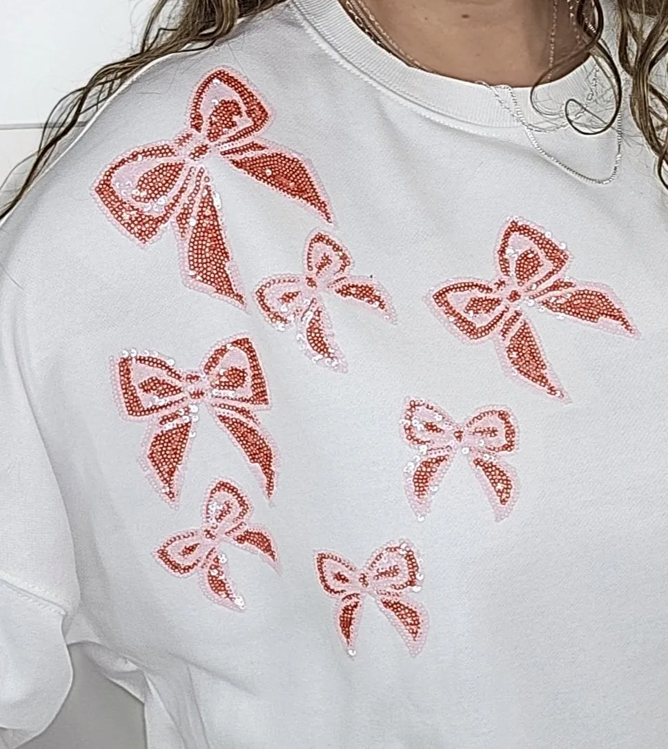 WHITE SEQUIN BOW ACCENT HI LOW PULLOVER